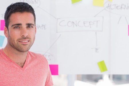 Designer standing in front of whiteboard with concept flowchart