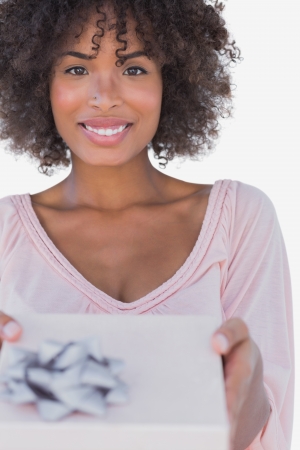 Happy woman offering a gift on white backgroundの写真素材