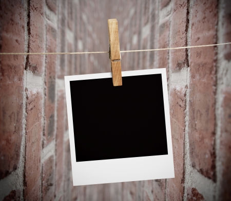 Instant print transfer hung with peg with bricks wall on the backgroundの写真素材