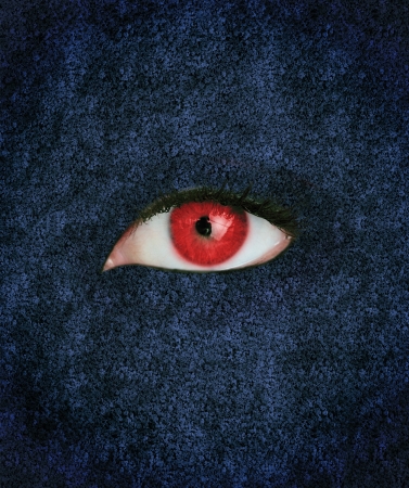 Red eye with eyelashes over blue texture の写真素材