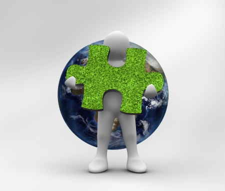 Human representation holding a grass jigsaw puzzle with planet on the backgroundの写真素材