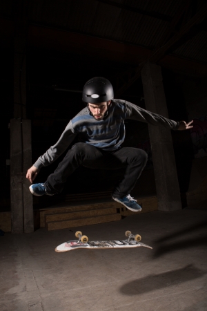 Skater wearing helmet doing kickflip trick in the skate parkの写真素材