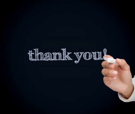 Woman writing thank you with a chalk on blackboardの写真素材