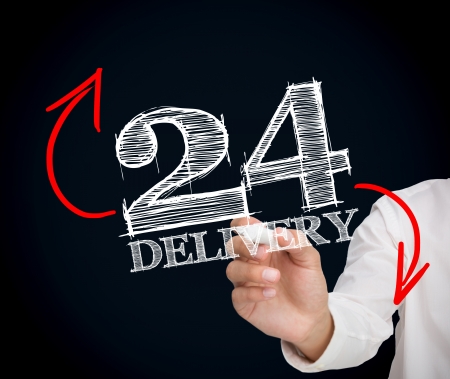 Businesswoman writing 24 delivery on black backgroundの写真素材