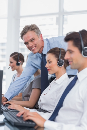 Call centre working with headset in a bright officeの写真素材