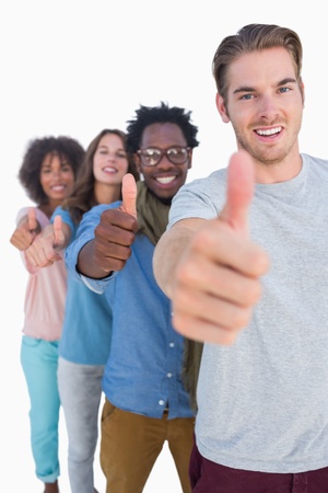 Cheerful people in row with thumbs up against white backgroundの写真素材