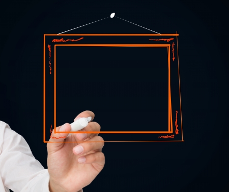 Businessman drawing picture frame on black backgroundの写真素材