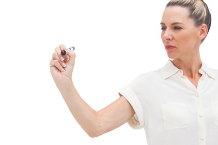 Serious businesswoman looking at pen in her right handの写真素材