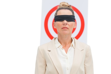 Businesswoman blindfolded and target behind herの写真素材