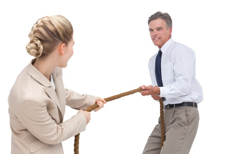 Smiling business people competing in pulling rope on white backgroundの写真素材