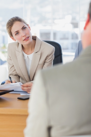 Smiling businesswoman looking at interviewee in the office の写真素材