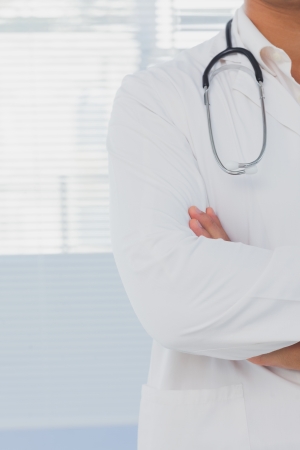 Doctor with arms crossed in a bright hospitalの写真素材