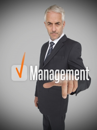 Businessman selecting the word management on futuristic interfaceの写真素材