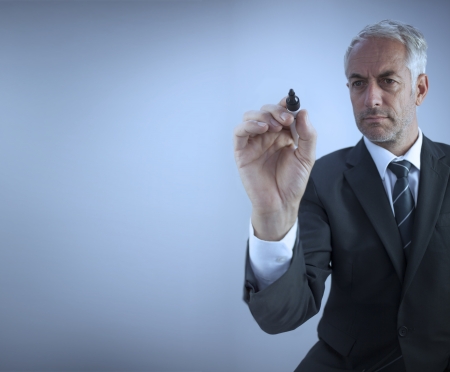 Businessman holding a marker on blue background