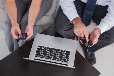 Overhead of colleagues using their mobile phone in officeの写真素材