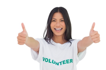 Woman wearing volunteer tshirt giving thumbs up on white backgroundの写真素材
