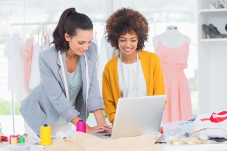 Fashion designers working on a laptop in a creative officeの写真素材