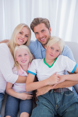 Cute family sitting on couch in the living roomの写真素材