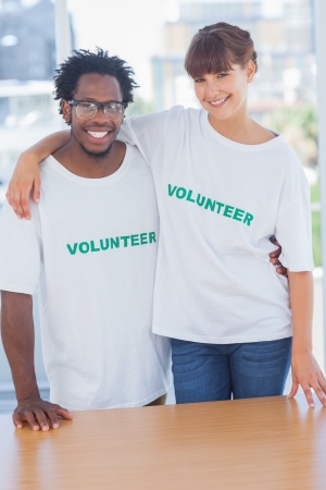 Volunteers embracing each other in their officeの写真素材