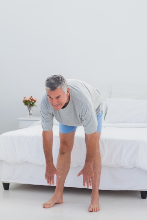 Mature man working out in his bedroomの写真素材
