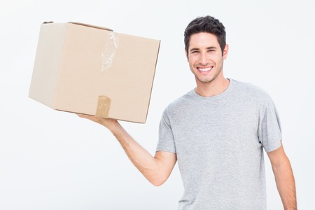 Cheerful man holding a box with one handの写真素材