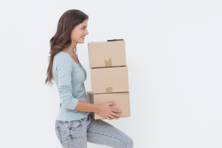 Attractive woman holding boxes because she is moving in a new house の写真素材