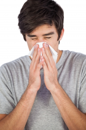 Man blowing his nose on a white backgroundの写真素材