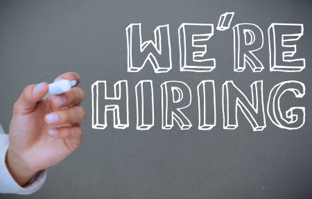 Hand writing we're hiring on grey backgroundの写真素材