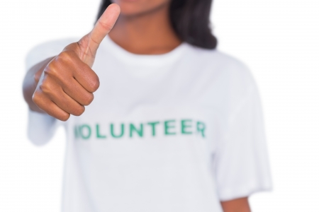 Woman wearing volunteer tshirt and giving thumb up on white backgroundの写真素材