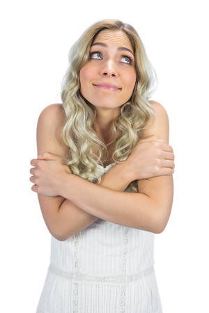 Curly haired blonde on white background being coldの写真素材