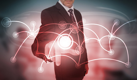 Businessman selecting futuristic circle with connecting lines interface on blurry office backgroundの写真素材