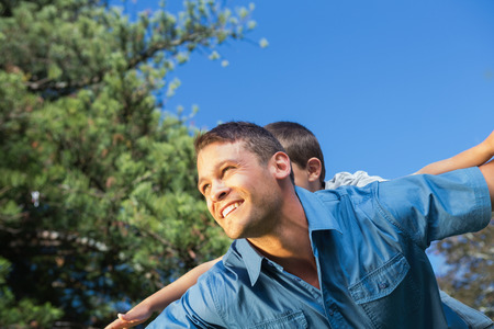 Father and son playing in a park on a sunny dayの写真素材
