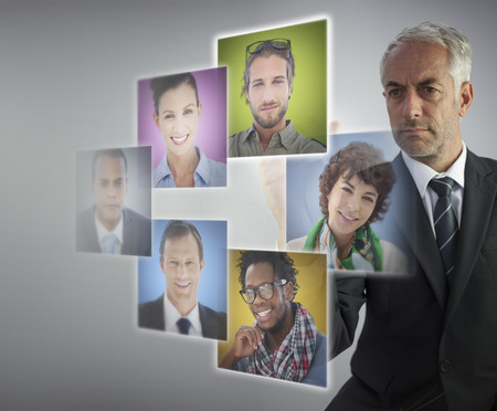 Mature human resources director selecting future employees on digital screensの写真素材