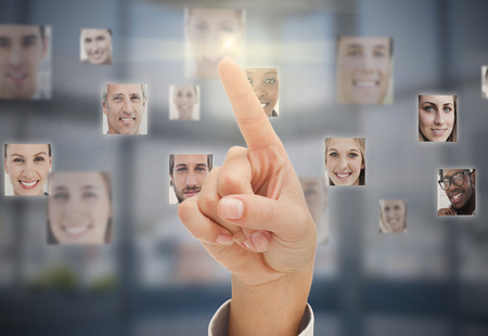 Finger touching futuristic interface showing human faces