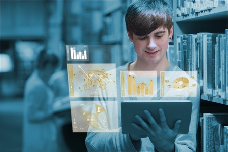 Young man studying on his digital tablet in a library
