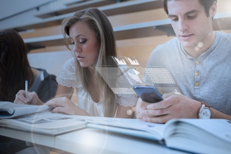 Concentrated college student working on futuristic smartphone in lecture hall