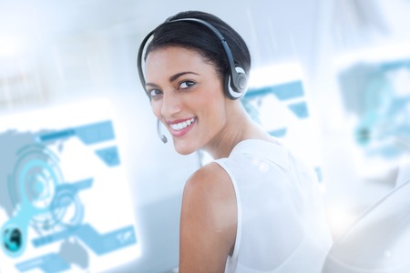 Pretty call center employee using futuristic holographic interface smiling at the camera in office