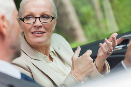 Business people working together in cabriolet on a bright dayの写真素材