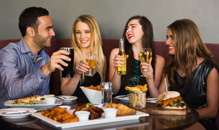 Friends having dinner together and toasting in a restaurant