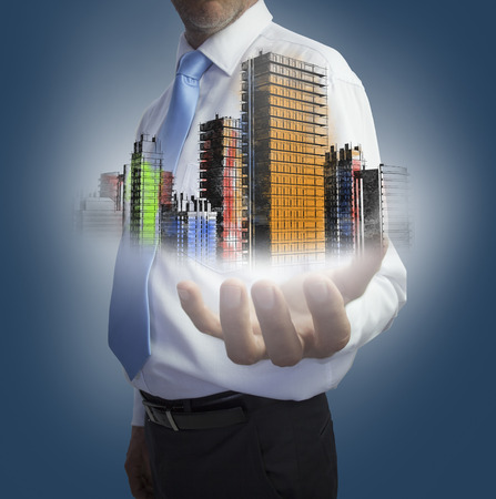 Close up of hand showing colored holographic city on dark backgroundの写真素材