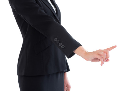 Mid section of young businesswoman pointing on white backgroundの写真素材