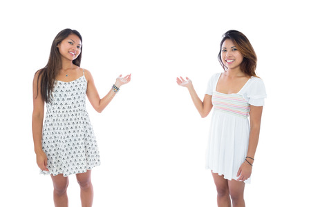 Two pretty asian women presenting on white backgroundの写真素材