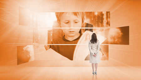 Rear view of businesswoman looking at pupil holding papers in orange lightの写真素材