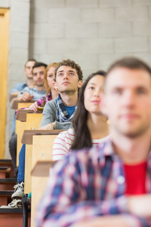 Close-up of young students sitting in a row at the college classroomの写真素材
