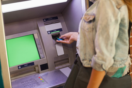 Student withdrawing cash at an ATMの写真素材
