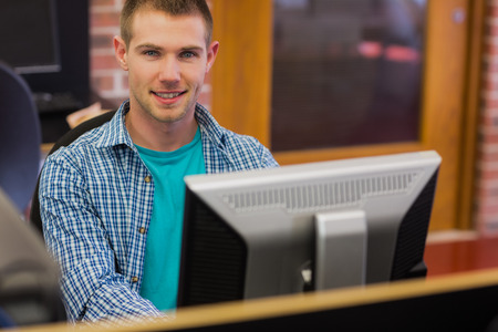 Portrait of young male student using computer in the computer roomの写真素材