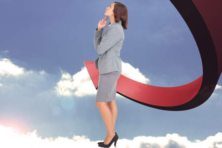 Focused businesswoman against red arrow pointing downの写真素材