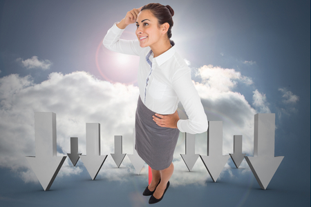 Smiling thoughtful businesswoman against cloudy sky backgroundの写真素材
