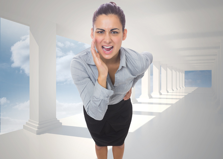 Businesswoman shouting against bright white hall with columnsの写真素材