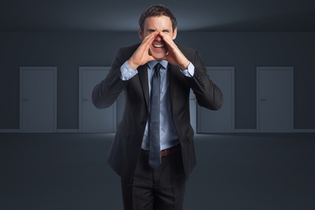 Shouting businessman against door opening to show red arrowの写真素材